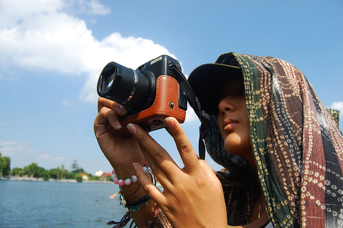 Ragazza che lavora nel terzo settore scatta una foto con macchina fotografica digitale